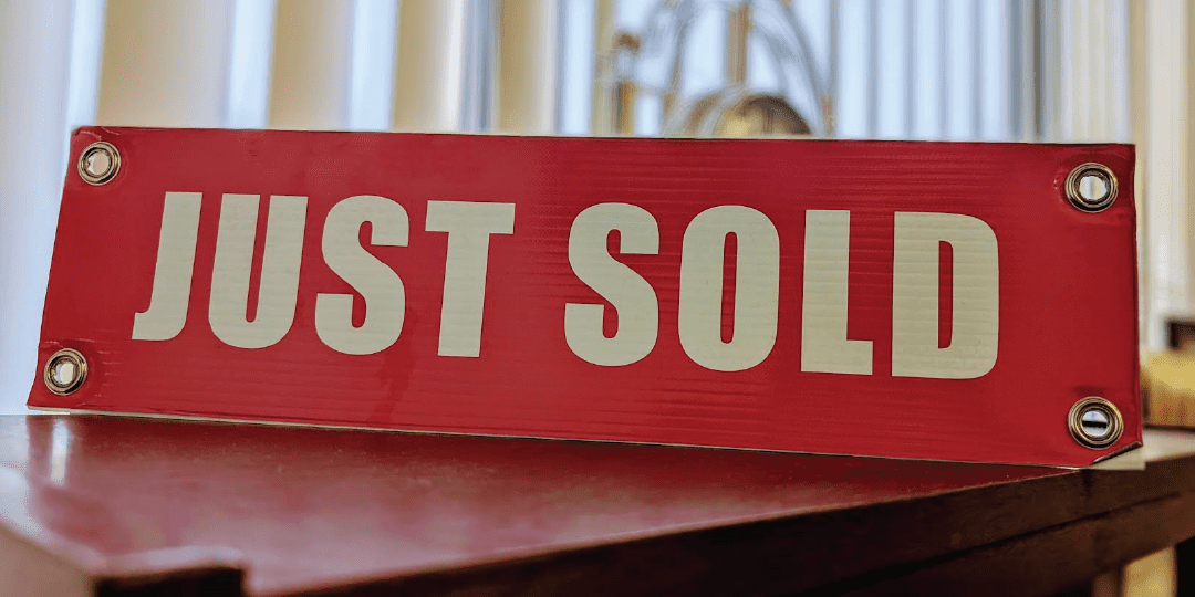 Red Just Sold Sign Displayed On A Table